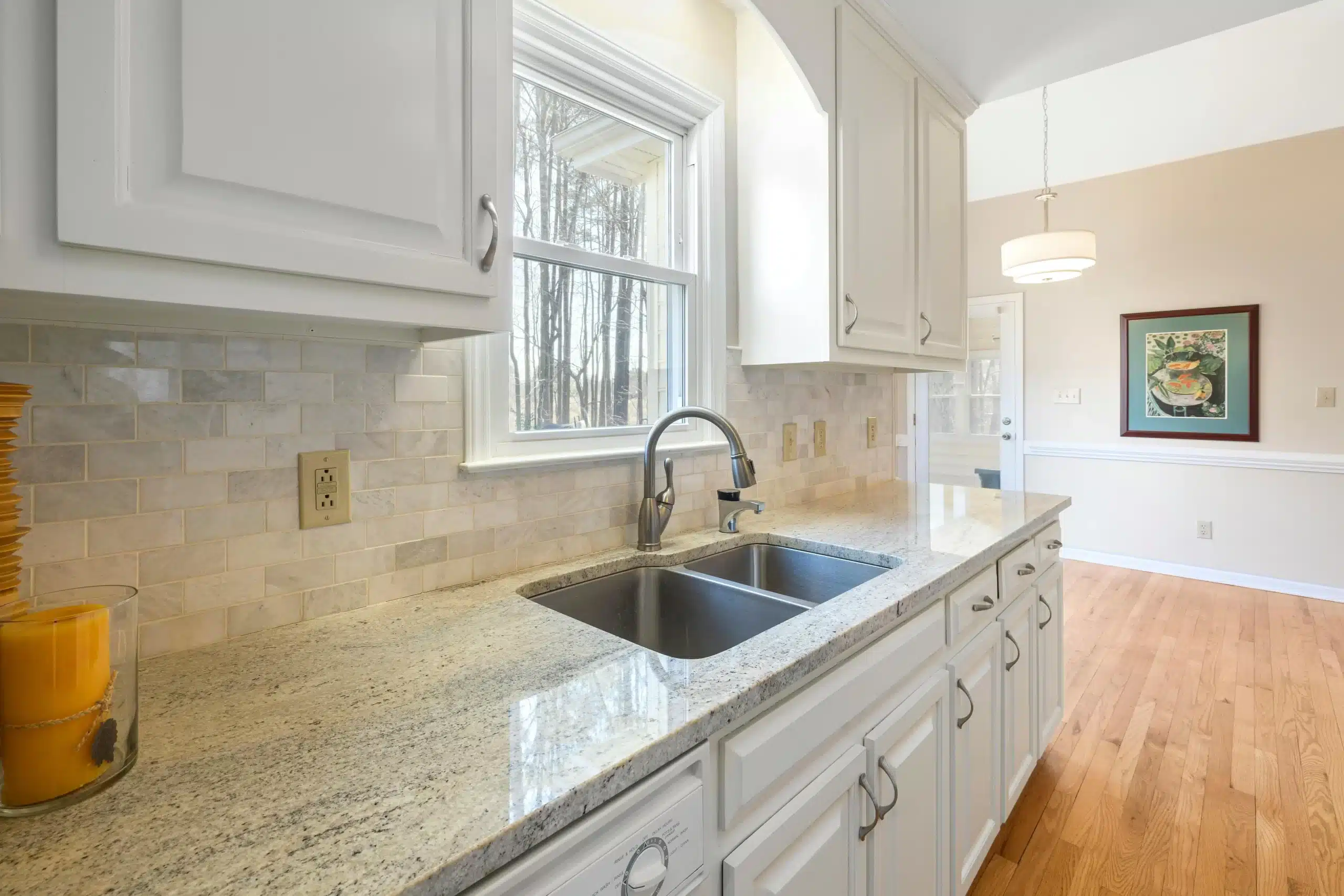 a kitchen with white cabinets and granite counter tops